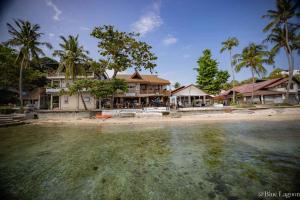 a house on the beach next to the water at Blue Lagoon Dive Resort in Sabang