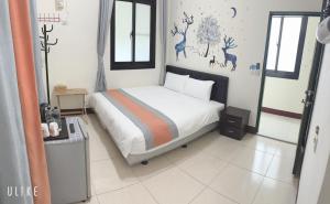 a bedroom with a bed with deer decals on the wall at Sun Good Hostel in Hengchun South Gate