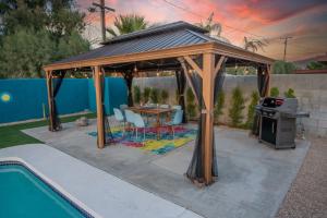 a wooden gazebo with a table and a stove at Rather Be Desert Getaway in Bermuda Dunes