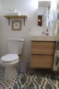 een badkamer met een wit toilet en een wastafel bij Sunnyside Up Apartment in Denver