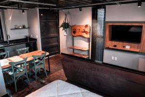 a dining room with a table and chairs and a tv at Cambará Container in Cambará