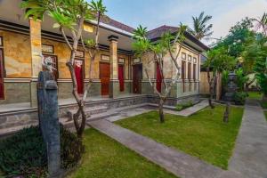 a house with trees in front of it at Kputra Homestay in Amed