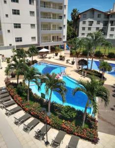 an overhead view of a swimming pool with chairs and palm trees at Veredas Rio quente flat in Rio Quente