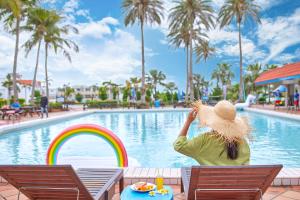a woman sitting in a chair in front of a pool at Uni-Resort Kenting in Eluan