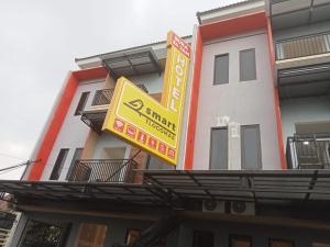 um edifício com um sinal amarelo em frente em Smart Tlogomas Syariah em Malang