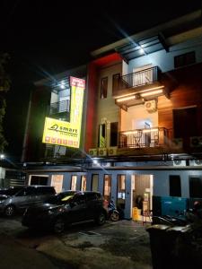 um edifício com carros estacionados num parque de estacionamento à noite em Smart Tlogomas Syariah em Malang