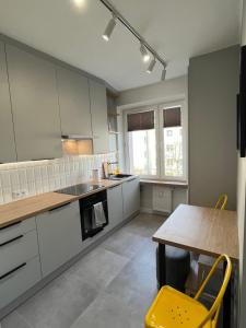 a kitchen with white cabinets and a table at Apartament RZ in Gdynia