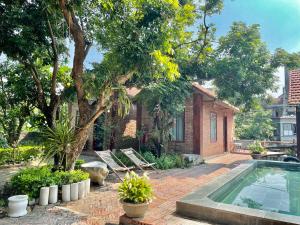 Un patio trasero con piscina y una casa. en Anh Huong Tam Coc Homestay, en Ninh Binh
