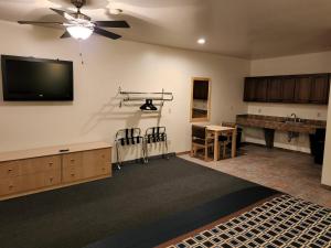 Una sala de estar con un televisor de pantalla plana en la pared. en Mecca Motel, en Colorado Springs