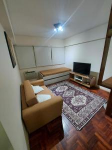 una pequeña sala de estar con sofá y TV en Alquiler Departamento Centro Mendoza Capital en Mendoza