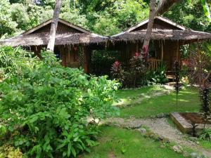 una casa con tetto di paglia in un giardino di Aventura Bed and Breakfast a San Juan