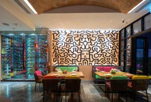 a restaurant with tables and chairs and a patterned wall at Eastin Grand Hotel Sathorn in Bangkok