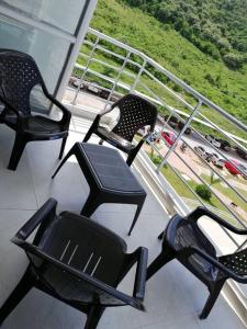 three chairs on a balcony with a view of a highway at Acogedor apartamento en Girardot: Aqualina Orange in Girardot