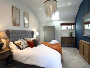 a bedroom with a large bed and a chandelier at The Tyre Barn in Whitchurch