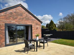 a patio with a table and chairs and a piano at The Tyre Barn in Whitchurch