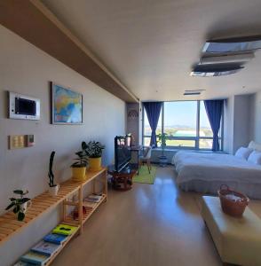 ein Schlafzimmer mit einem großen Bett und einem großen Fenster in der Unterkunft Cozy - Good Vibes Studio in Incheon