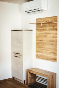 a kitchen with a refrigerator and a wooden table at Apartma Moser in Podnanos
