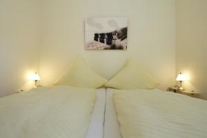 2 camas brancas num quarto com 2 candeeiros em Ferienwohnung Mare Nostrum 8 em Westerland