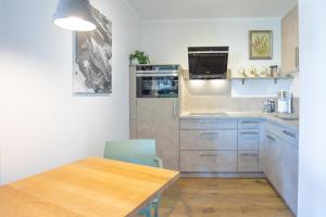 a small kitchen with a wooden table and a table and a counter at Hafenmeister in Husum