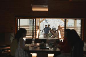 a group of people sitting at a table in a restaurant at Little Hermit by SANA in Tateyama