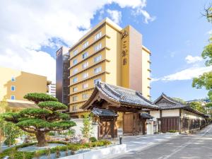 高知三翠园酒店的一座建筑前有树的酒店