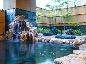 a water feature in a pool with a waterfall at Sansuien in Kochi