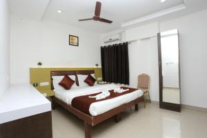 een slaapkamer met een bed en een plafondventilator bij GM Residency in Chennai