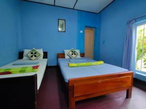 2 letti in una camera con pareti blu di The 1964 Holiday bungalow a Ella