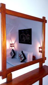 a mirror reflecting a bed with two pillows on it at Ella Secret Paradise in Ella