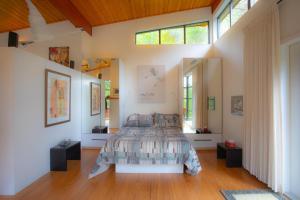 a bedroom with a bed and some windows at Moon Dance Perch in Madeira Park