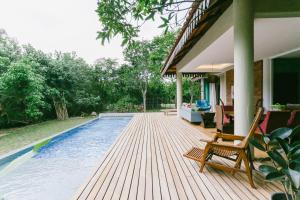 um deque de madeira com uma piscina numa casa em Royale Riviera Resort Private Pool Villas em Pantai Cenang