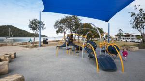 une aire de jeux dans un parc avec un toboggan dans l'établissement Coastal Cottage - Ettalong Beach, à Ettalong Beach 3 autres photos