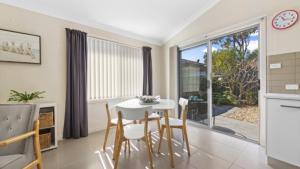 a kitchen and dining room with a table and chairs at Ocean Sounds - Umina Beach in Umina