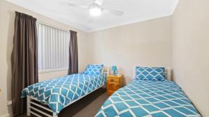 a bedroom with two beds and a window at Ocean Sounds - Umina Beach in Umina