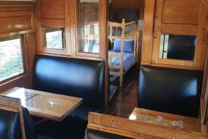 a train room with chairs and a table and a bed at Carriages Waterfront in Wharparilla