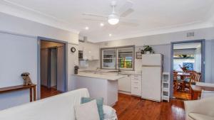 a kitchen and living room with a white refrigerator at Lazy Days Seaside Cottage - Umina Beach in Umina