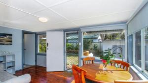 a dining room with a table and chairs at Lazy Days Seaside Cottage - Umina Beach in Umina