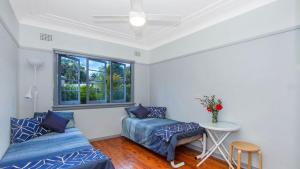 سرير أو أسرّة في غرفة في Lazy Days Seaside Cottage - Umina Beach