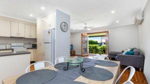 a kitchen and living room with a table and chairs at Edendale Family Fun - Ettalong Beach in Ettalong Beach