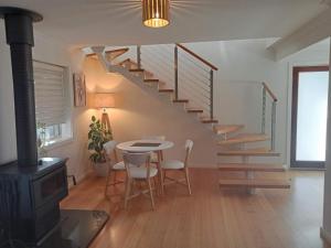 a dining room with a table and a spiral staircase at Riesling Trail & Clare Valley Cottages in Clare