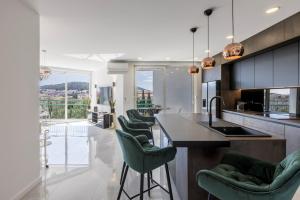 eine Küche mit grünen Stühlen und eine Kücheninsel in der Unterkunft Carmen - Luxury 2-Bedroom Apartment - Downtown in Split