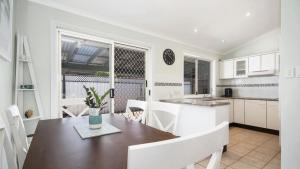 a kitchen and dining room with a table and chairs at Beach Daze - Umina Beach Family Friendly in Umina