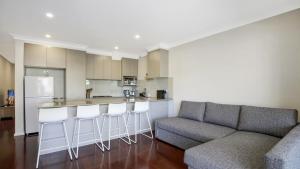 a living room with a couch and a kitchen at Beachbound - Booker Bay Wifi in Booker Bay