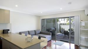 a kitchen and living room with a couch and a table at Beachbound - Booker Bay Wifi in Booker Bay