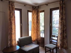 sala de estar con sofá, mesa y ventanas en Villa Maxim, en Varna