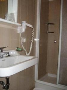 W łazience znajduje się umywalka i prysznic. w obiekcie Hotel Riviera w mieście Cadenabbia