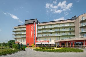 ein Hotel mit einem roten Gebäude davor in der Unterkunft Terma Słowacki Resort Medical Spa in Busko-Zdrój