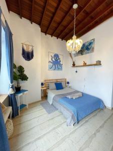 um quarto com uma cama e um lustre em Octopus Blue em Míconos
