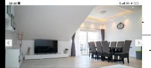 une salle à manger avec une table, des chaises et une horloge dans l'établissement Apartmentt Vinko Bilota, à Seget Vranjica