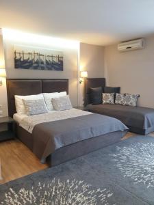 una camera con due letti e un divano di Apartmani Kameno Sidro a Bilice (Bilizze)